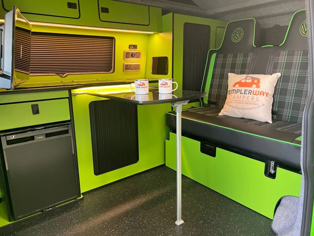 green interior van conversion with cups and branded pillow